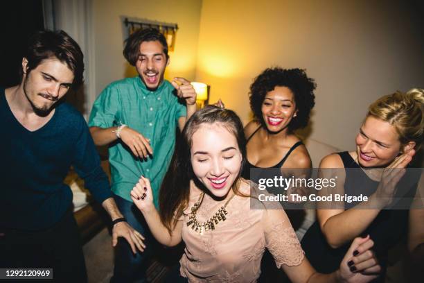 happy multi-ethnic male and female friends dancing during party at home - the party inside stock pictures, royalty-free photos & images