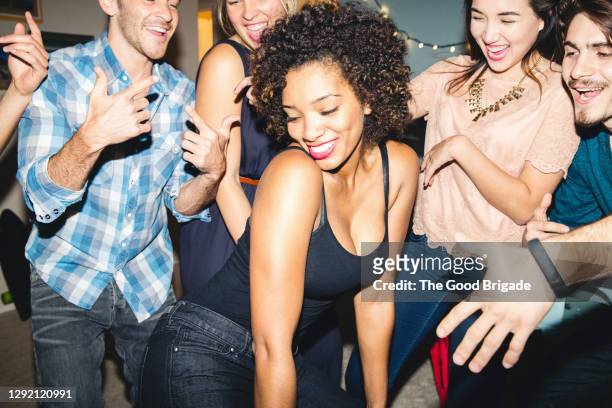 multi-ethnic friends cheering woman dancing during party at home - home party ストックフォトと画像