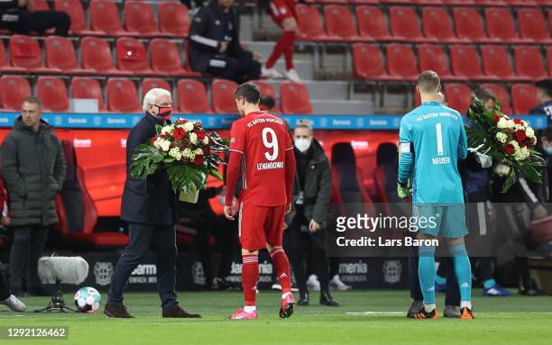 Bayern Munich's Robert Lewandowski and Manuel Neuer each receive a bouquet of flowers from Rudi Voller, Sporting Director of Bayer 04 Leverkusen...