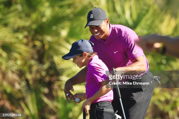 Tiger Woods of the United States and Charlie Woods react on the third green during the first round of the PNC Championship at the Ritz-Carlton Golf...