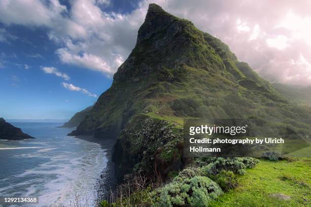 hiker walking along the wild coast of madeira, portugal - madeira portugal stock pictures, royalty-free photos & images
