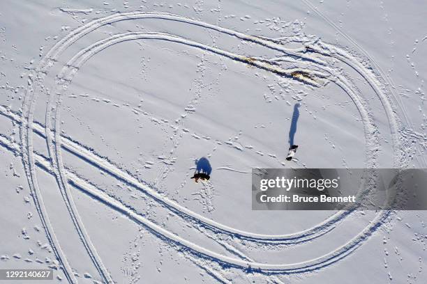 In an aerial view shot with a drone, a visitor plays with her dog after this week's snow in Bethpage State Park on December 19, 2020 in Bethpage, New...