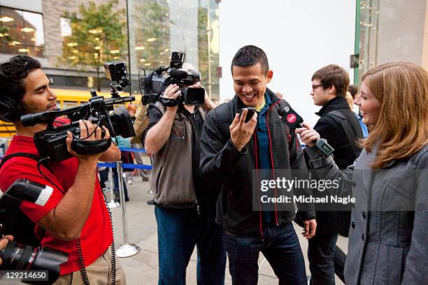 Travis Ahking's first moments with his new Apple iPhone 4s are documented by the media outside of the Apple Store on Broadway and 67th Street on...