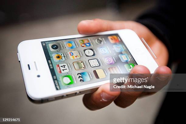 An Apple customer displays his newly purchased iPhone 4s outside of the Apple Store on Broadway and 67th Street on October 14, 2011 in New York City....