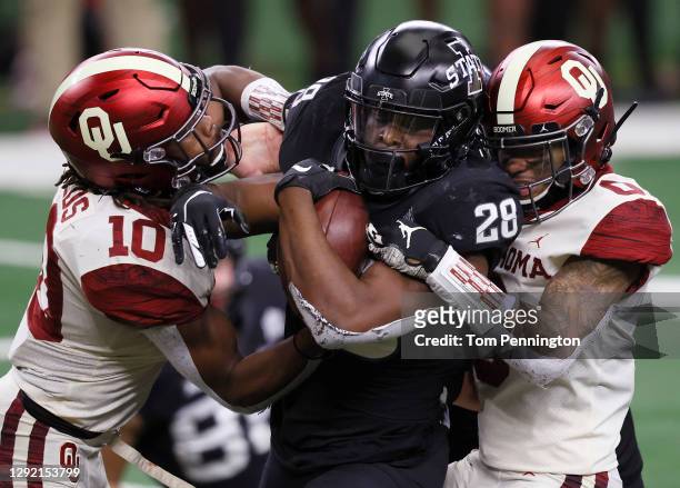 Breece Hall of the Iowa State Cyclones carries the ball to score a touchdown against Pat Fields of the Oklahoma Sooners and Woodi Washington of the...