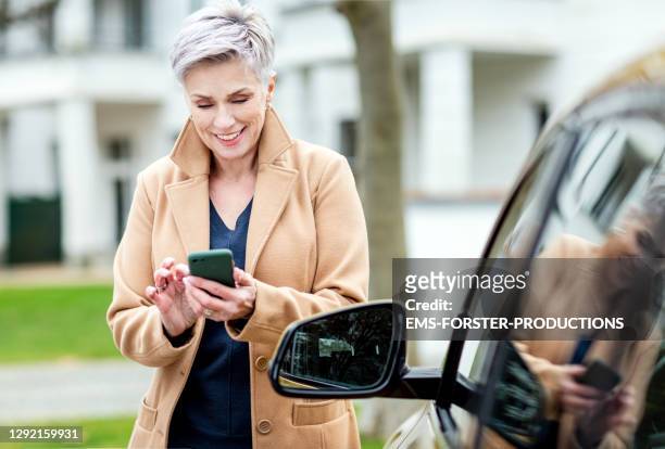 senior woman is using car sharing in munich - kombinerad mobilitet bildbanksfoton och bilder