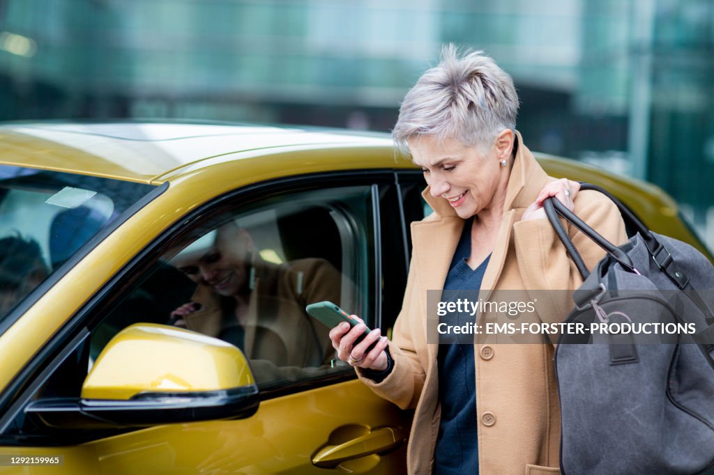 Active, female adult is using smart phone to unlock a rental car - carsharing