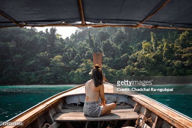 tourists young asian woman on long tailed boat at koh phi phi island, phuket, thailand. - longtailboot stockfoto's en -beelden