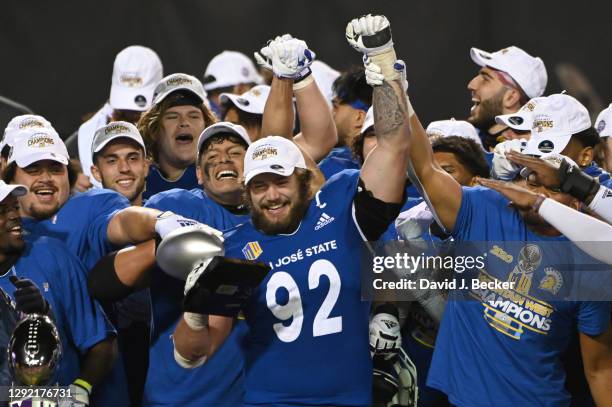 Defensive lineman Cade Hall of the San Jose State Spartans raises the Mountain West Championship game defensive MVP trophy after the team defeated...
