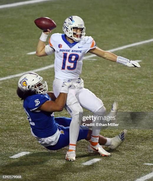 Quarterback Hank Bachmeier of the Boise State Broncos gets rid of the ball as he is brought down by defensive end Viliami Fehoko of the San Jose...