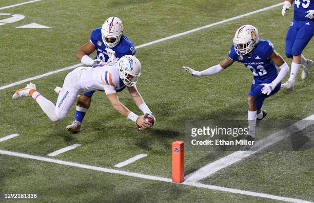 Quarterback Hank Bachmeier of the Boise State Broncos dives to score on a 2-yard touchdown run against defensive lineman Jay Kakiva and cornerback...