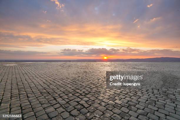 empty cobblestone street at sunset - acciottolato foto e immagini stock