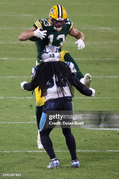 Wide receiver Allen Lazard of the Green Bay Packers carries the ball against the defense of free safety Tre Boston of the Carolina Panthers during...