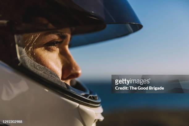 close-up of woman wearing motorcycle helmet - motociclista fotografías e imágenes de stock
