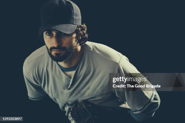 confident male baseball player against black background - baseball pitcher isolated stock pictures, royalty-free photos & images