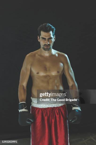 portrait of confident male boxer standing against black background - fighter portraits 2015 stockfoto's en -beelden