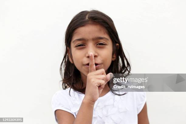 6-7 years girl putting index finger on lips - 4 5 years stock pictures, royalty-free photos & images