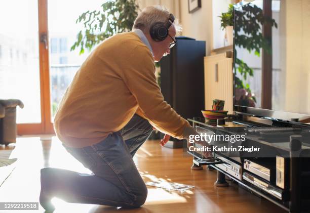 senior man listening to music at home - hi fi fotografías e imágenes de stock