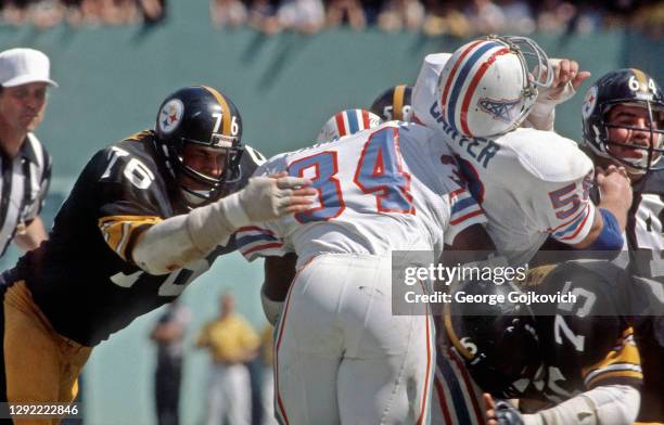 Defensive linemen John Banaszak and Joe Greene of the Pittsburgh Steelers tackle running back Earl Campbell of the Houston Oilers as offensive...