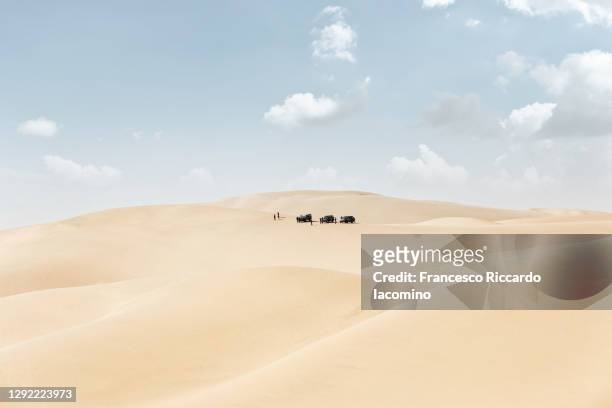 namib desert, dead vlei, namibia, africa. offroad veichles on sand dunes, cloudy blue sky. - kalahari desert stockfoto's en -beelden