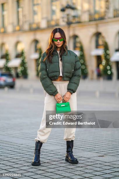 Patricia Gloria Contreras wears neon colored shiny sunglasses from Quay, a green winter bomber puffer jacket from Nastygal, a white cropped top from...