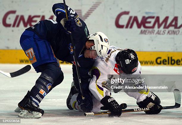 Jason Ulmer of Muenchen vies for the puck with Andreas Driendl of Krefeld during the DEL match between EHC Muenchen and Krefeld Pinguine at Olympia...