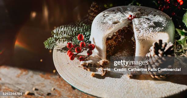 traditional luxury iced christmas fruit cake, decorated with holly, berries, fern and acorns. - christmas cake stock pictures, royalty-free photos & images