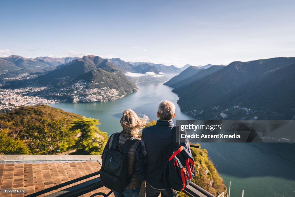 Randonnée de couples mûrs au-dessus du lac Lugano le matin