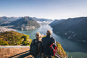 Mature couple hike above lake Lugano in the morning