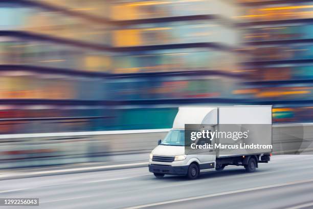 snelle bestelwagen die door de straten van de stad reist - moving truck stockfoto's en -beelden