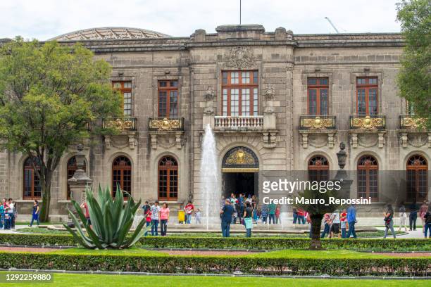 people walking next to a water fountain at the entrance of the chapultepec castle at mexico city, mexico. - castillo de chapultepec stock pictures, royalty-free photos & images