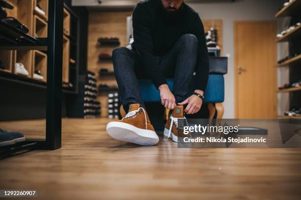 young man shopping shoes - mens footwear stock pictures, royalty-free photos & images