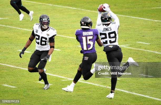 Safety Josh Jones of the Jacksonville Jaguars catches an interception intended for wide receiver Marquise Brown of the Baltimore Ravens during the...