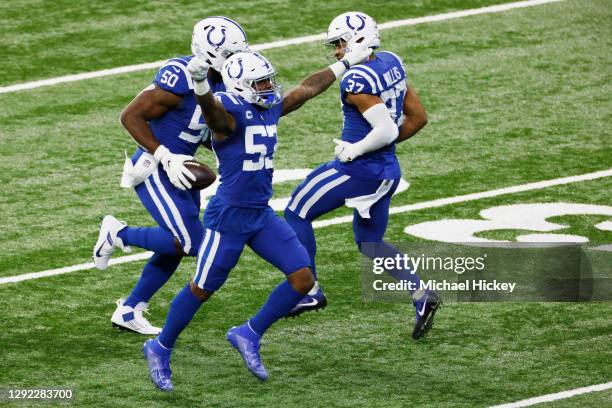 Justin Houston of the Indianapolis Colts celebrates a fumble recovery with Darius Leonard and Khari Willis in the first quarter against the Houston...