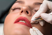 Permanent make up procedure. Lip makeup in tattoo salon.