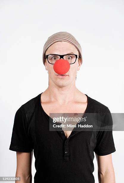 young man with black glasses and red clown nose - clown's nose stock pictures, royalty-free photos & images