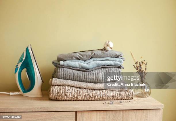 stack of clean clothes at home. concept of laundry, cleaning and housework. iron. - folded clothes stock pictures, royalty-free photos & images