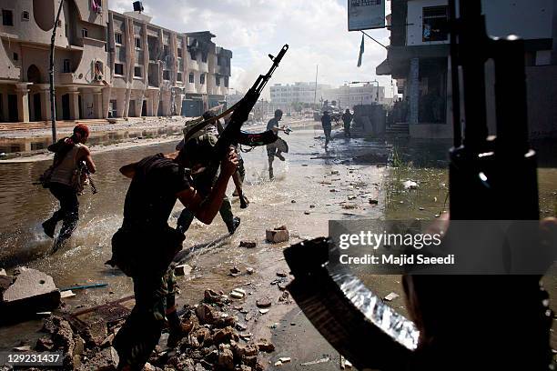 National Transitional Council fighters take part in a street battle in the center of the city on October 14, 2011 in Sirte, Libya. NTC fighters say...