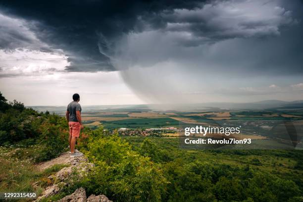 man watching beautiful storm clouds from the cliffs - caçador de tempestades imagens e fotografias de stock