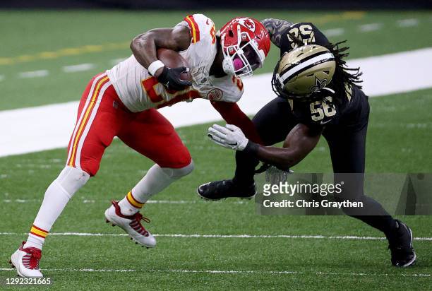 Le'Veon Bell of the Kansas City Chiefs is brought down by Demario Davis of the New Orleans Saints during the fourth quarter in the game at...