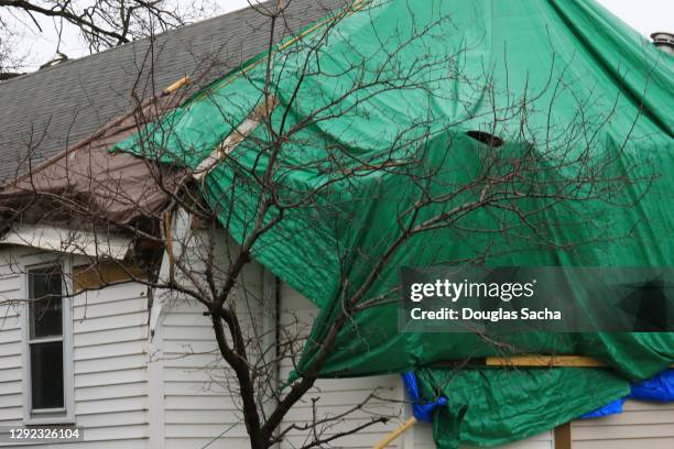 plastic cover on a house protecting from it after the storm - damaged roof stock pictures, royalty-free photos & images