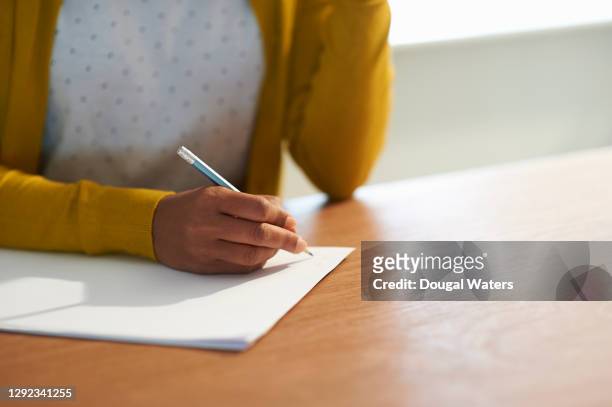 woman making notes with pencil and paper close up. - message stock-fotos und bilder