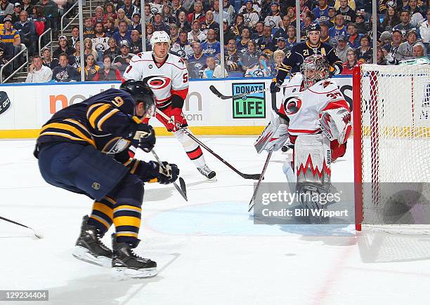 Derek Roy of the Buffalo Sabres scores a first period goal against the Cam Ward of the Carolina Hurricanes at First Niagara Center on October 14,...