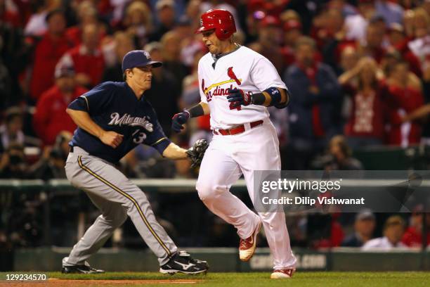 Yadier Molina of the St. Louis Cardinals avoids an attempted tag attempt by Zack Greinke of the Milwaukee Brewers as Molina scores by Jaime Garcia...