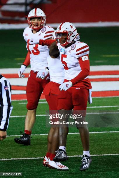 Cam Taylor-Britt of the Nebraska Cornhuskers celebrates his interception with Dicaprio Bootle as JoJo Domann of the Nebraska Cornhuskers looks on...