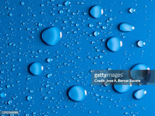 full frame of the textures formed by the bubbles and drops of water on a blue background. - regentropfen stock-fotos und bilder