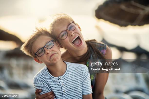 brother and sister embracing on beach - brother sister stock pictures, royalty-free photos & images