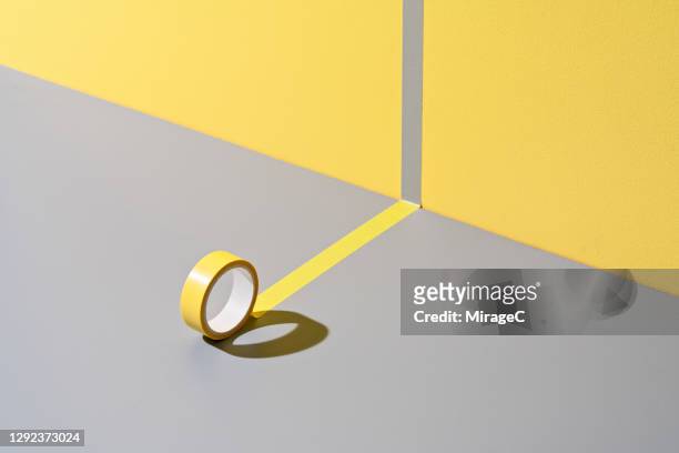 adhesive tape sticking to yellow and gray - separation foto e immagini stock