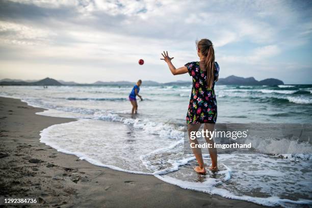 mother and daughter throwing ball on the beach - playing catch stock pictures, royalty-free photos & images