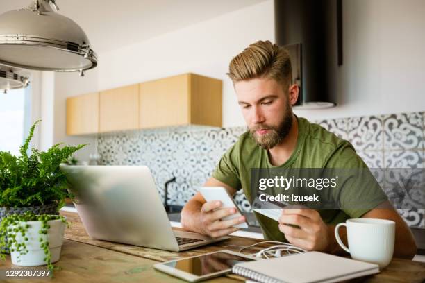 junger mann beim online-shopping - mann mit kreditkarte stock-fotos und bilder
